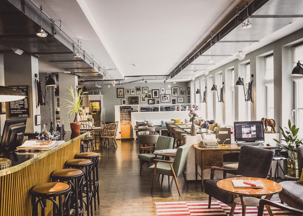 Het restaurant in zachte tinten, bar met barkrukken, hoge ramen