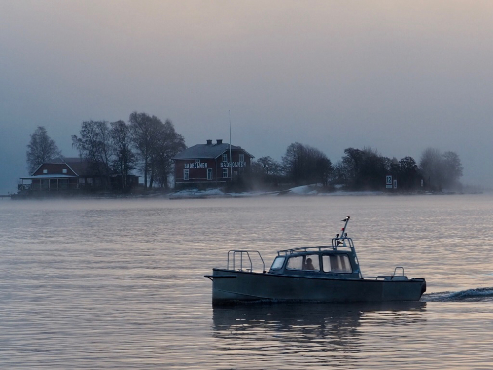 Sleepbootje voor een eilandje in de ochtend mist