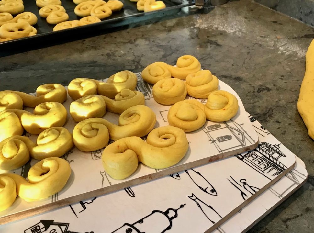 Ongebakken kaneelbroodjes op een bakplaat, klaar om de oven in te gaan