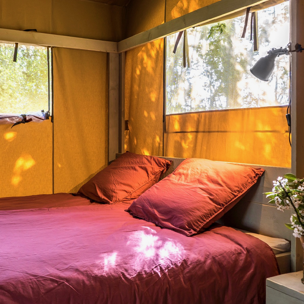 Tweepersoons opgemaakt bed in een safaritent bij Voedselbron Graauw