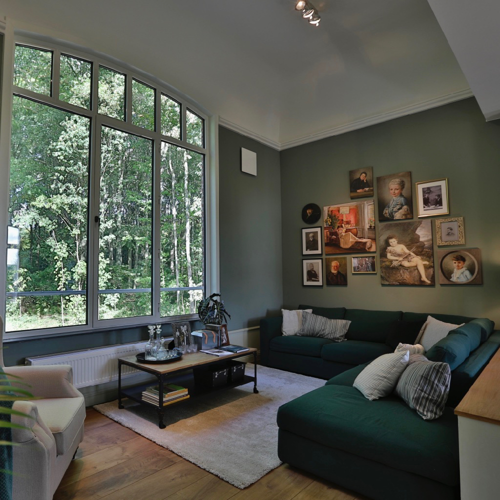 De zithoek in het vakantiehuis, met groot raam met uitzicht op het park