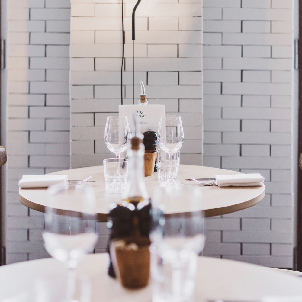 Ronde gedekte tafels met witte stenen muur