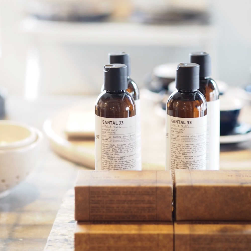 Vier flesjes op tafel met stukken zeep ervoor