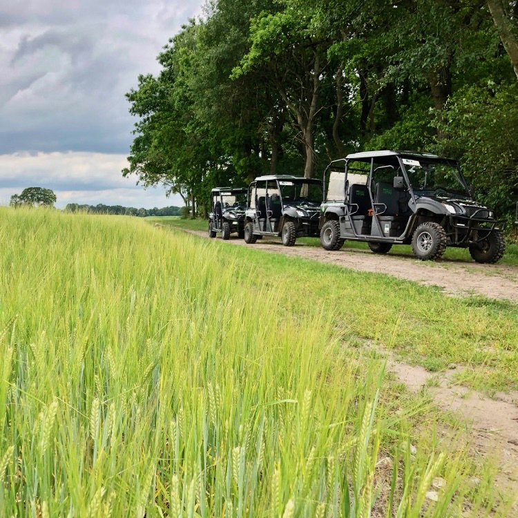 Drie elektrische terreinwagens aan de rand van een akker