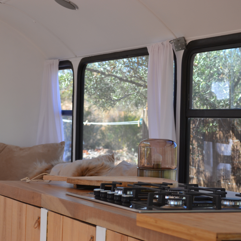 Schoolbus omgebouwd tot accommodatie, keukenblok met gasfornuis