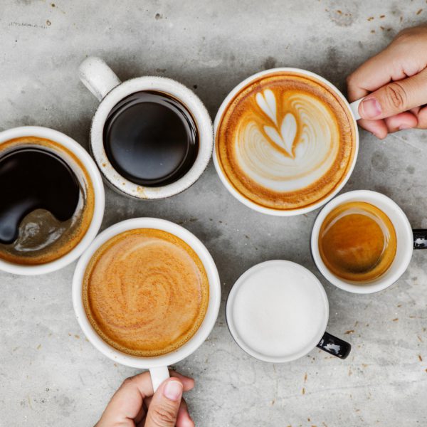 Verschillende kopjes koffie van bovenaf gefotografeerd