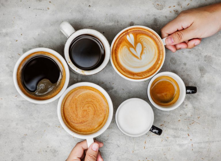 Verschillende kopjes koffie van bovenaf gefotografeerd