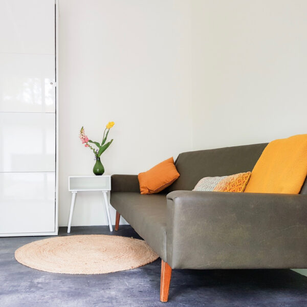 Groene bank met gele kussens in FINT Lauwersoog