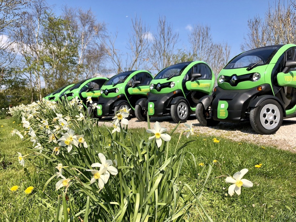 Een paar Twizy's op een rij aan de rand van de bollenvelden