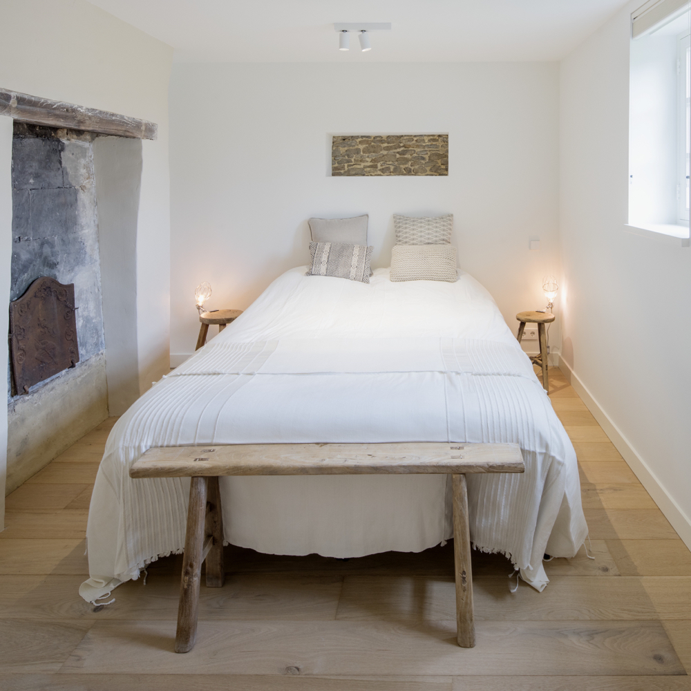 Tweepersoons bed met houten bankje in een vakantie appartement