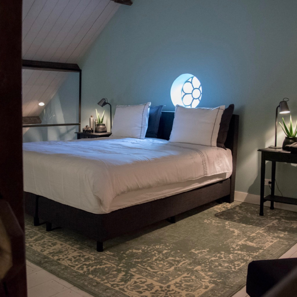 Tweepersoons bed met groot tapijt eronder