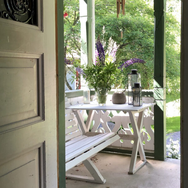 Wit bankje en wit tafeltje op de veranda