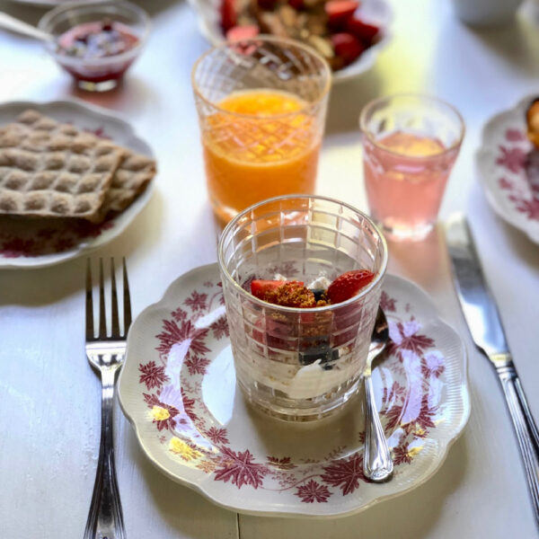 Glaasje yoghurt met vers fruit en glaasje sap