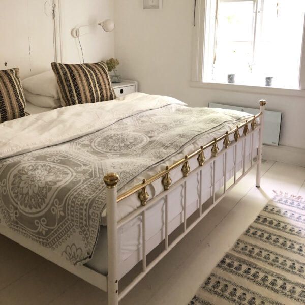 Gastekamer met wit en gouden stijlen bed