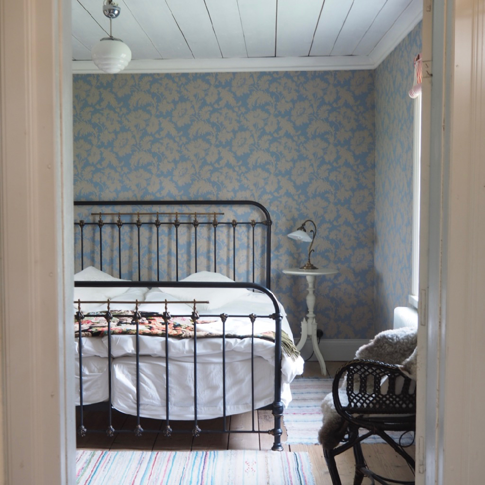 Spijlenbed voor lichtblauw bloemenbehang