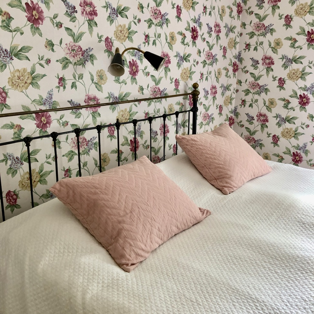 Romantisch spijlenbed en bloemetjesbehang