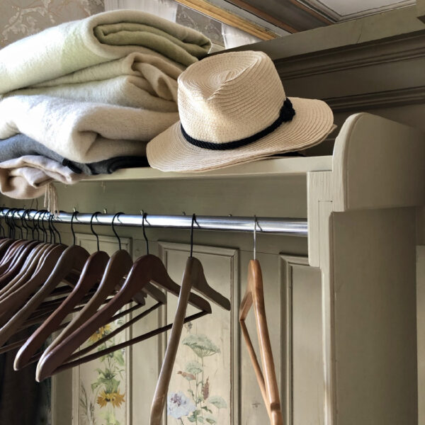 Hoed en stapel dekens bij de garderobe