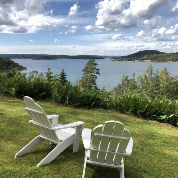 Witte beachchairs in het gras aan zee