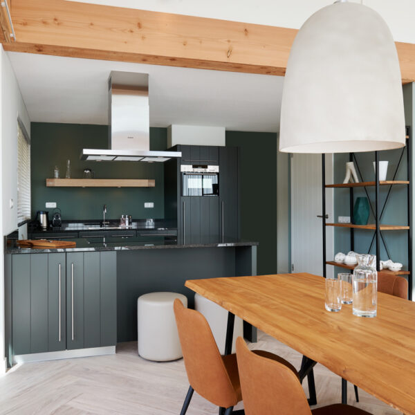 Zwarte keuken met stoeren houten tafel