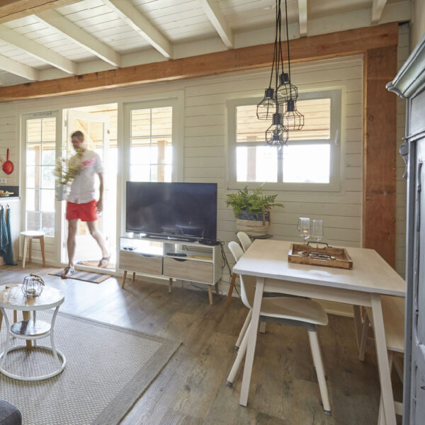 Man met vaas bloemen loopt vakantiehuis in