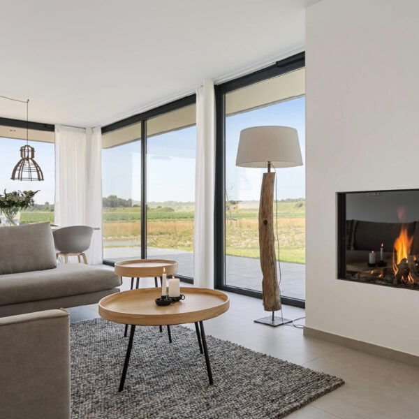 Brandende haard en ronde salontafels