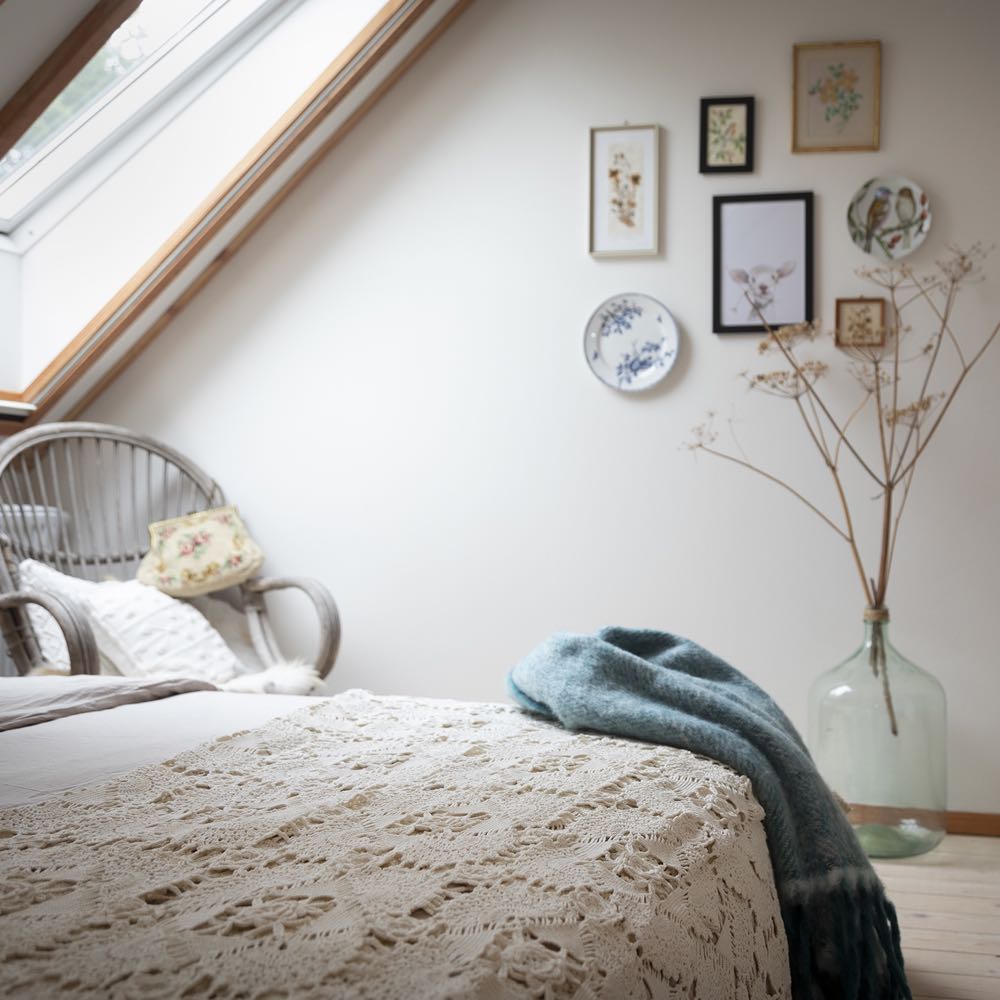 Slaapkamer met plant en schilderijtjes aan de wand
