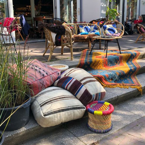 Kussen, stoeltjes en rotan zithoekje op het terras