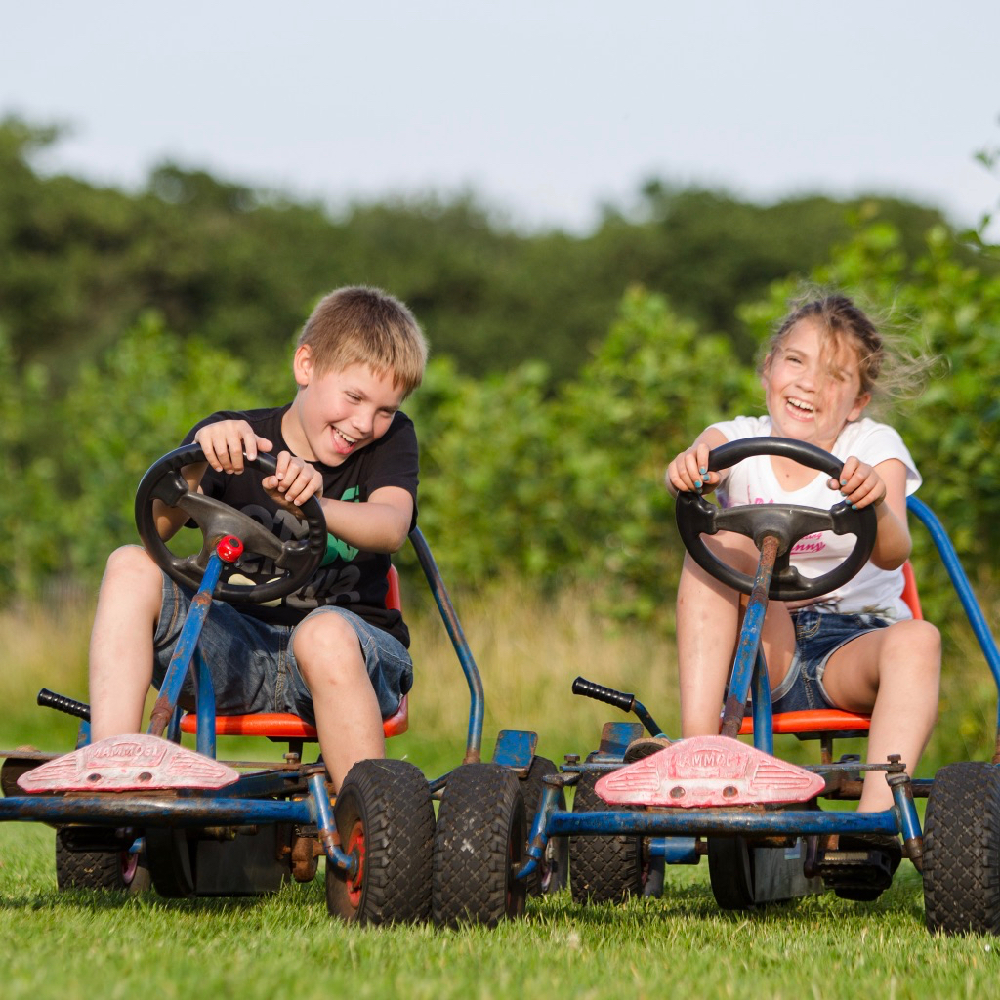Kinderen op skelters tijdens een weekendje weg bij het BoerenBed.