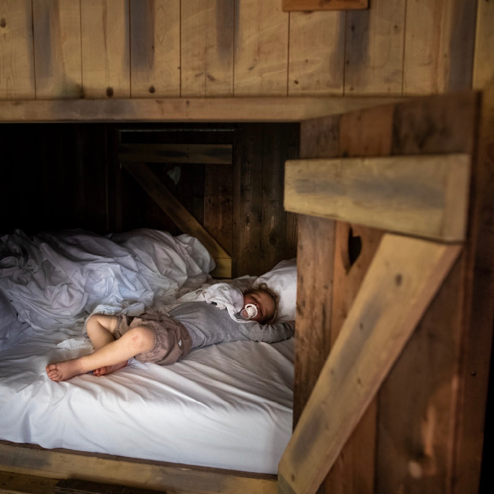 Kindje ligt te slapen in een bedstee in de BoerenBed Tent