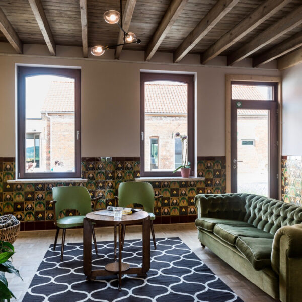 Zitkamer met groene fluwelen fauteuil en twee stoeltjes in het groen