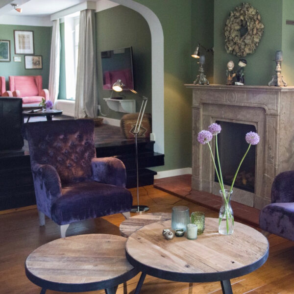 Hoek van de woonkamer met fauteuil en haard