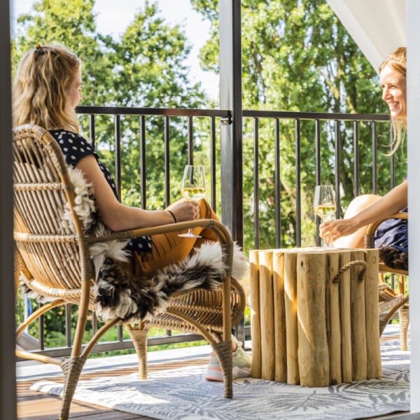 Genietende dames met een glaasje wijn op een balkon bij de suite
