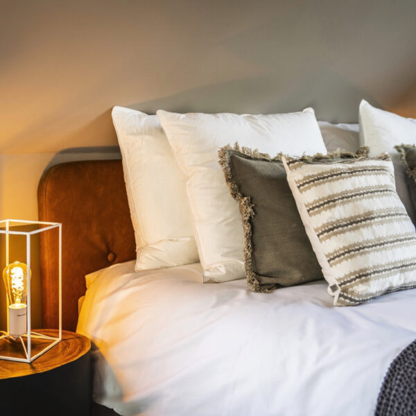 Opgemaakt bed in de suite met veel kussens