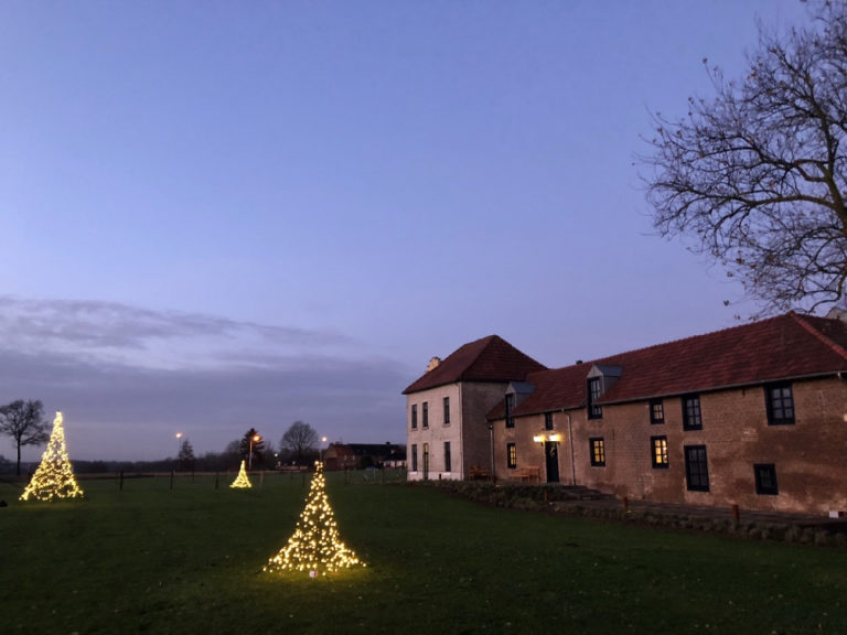 Verlichte kerstbomen in de tuin van Hoeve Beusdalshof