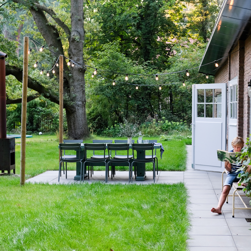 Tuin met lampjes, zithoek en buitenhaard