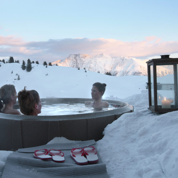 Drie vrouwen in een hot tub in de sneeuw