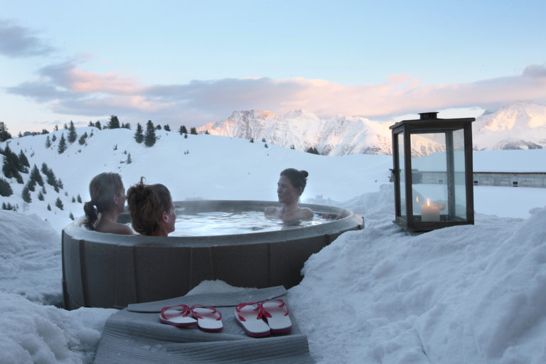 Drie vrouwen in een hot tub in de sneeuw