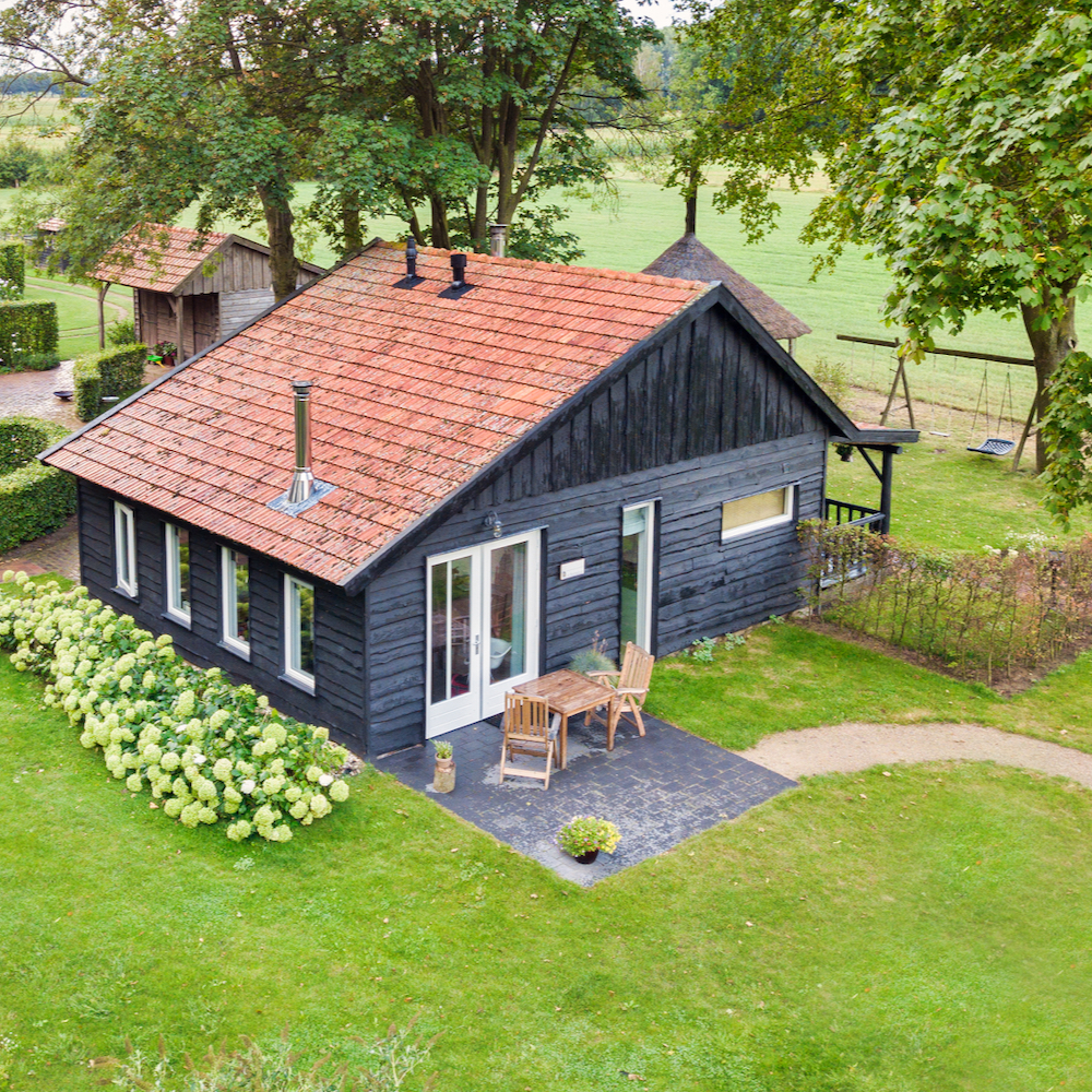 Luchtfoto van het zwarte houten huisje in de Achterhoek