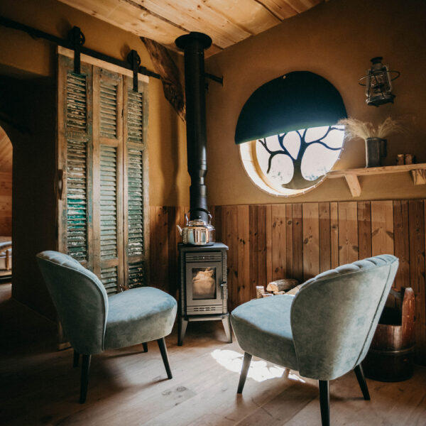 Fauteuils bij een houtkacheltje in het hobbit huisje