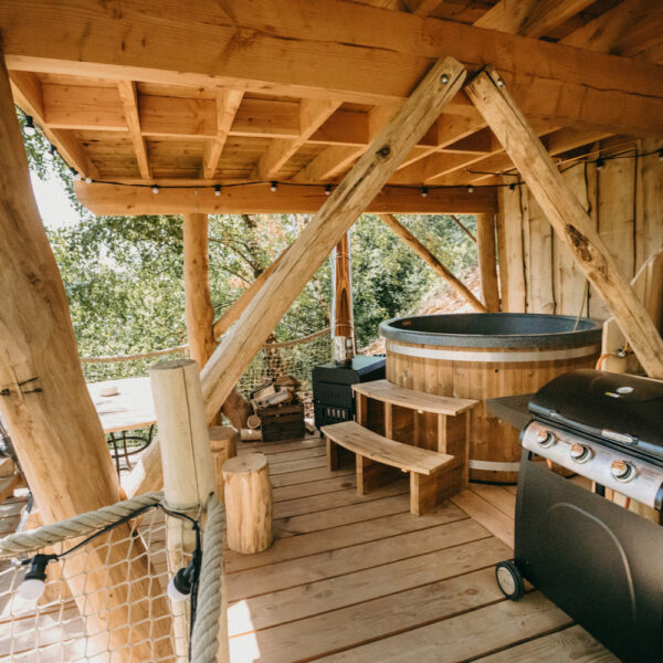 Boomhut met een hot tub op een overdekt terras