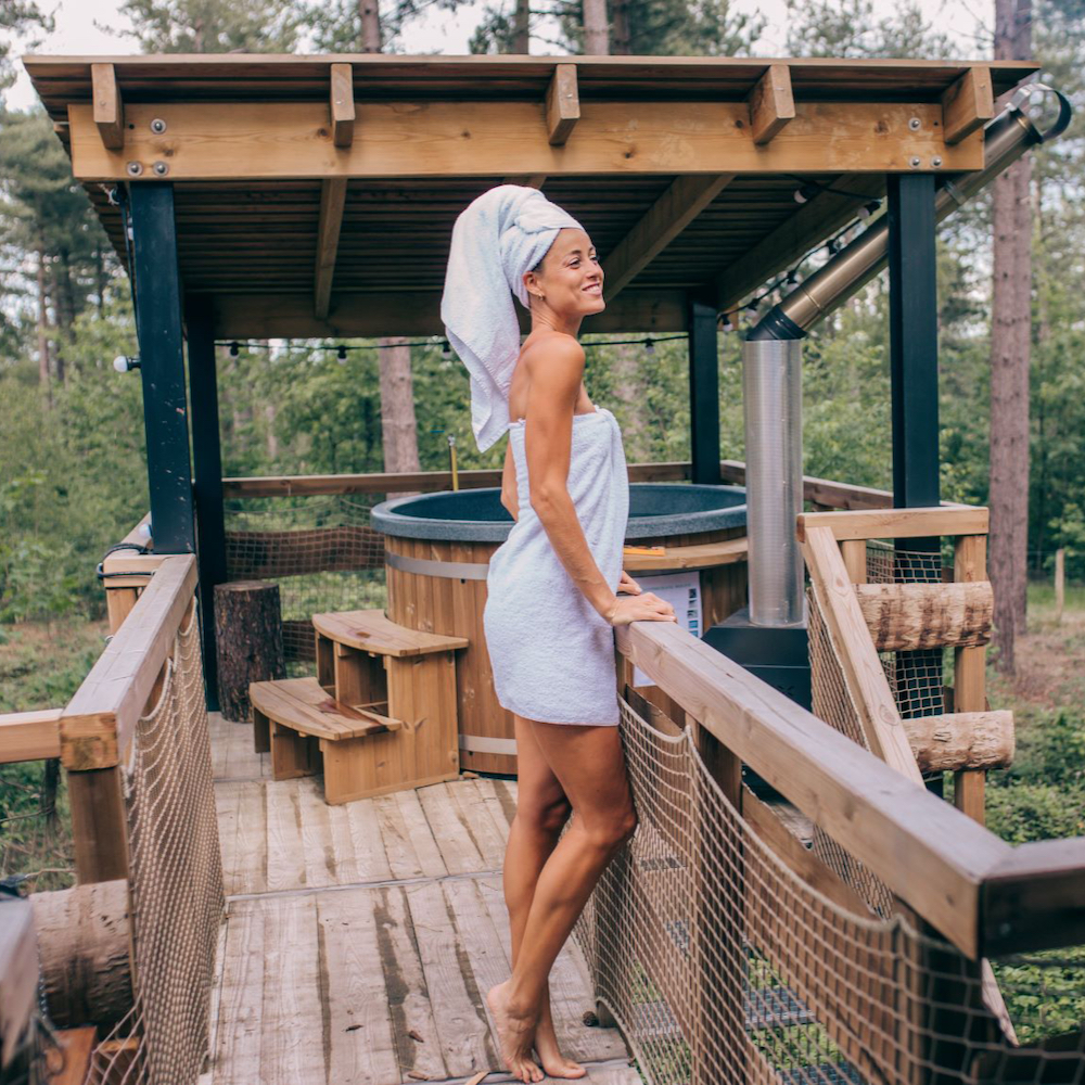 Dame met handdoek om bij de hot tub bij de cabin