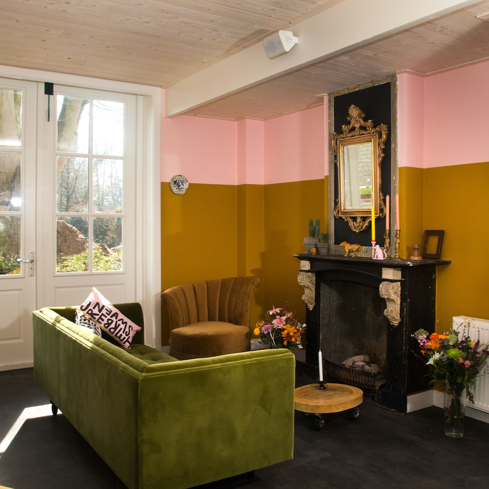 Zithoek met groene fluwelen bank bij de haard