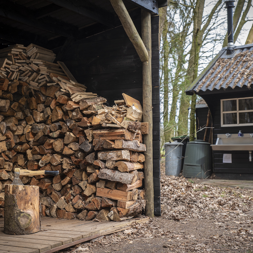 Stapel met hout bij het vakantiehuis in het bos