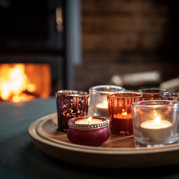 Brandende waxinelichtjes bij de haard