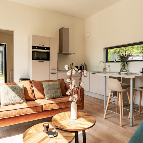 Compacte woonkamer met keuken en bar met krukken