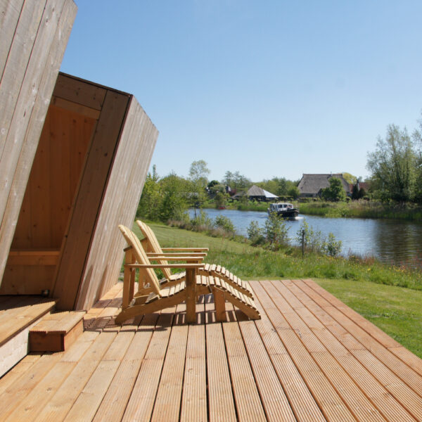 Huisje met twee ligstoelen aan het water