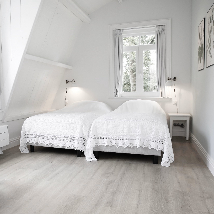 Witte opgemaakte bedden in een appartement, voor een vakantie aan zee