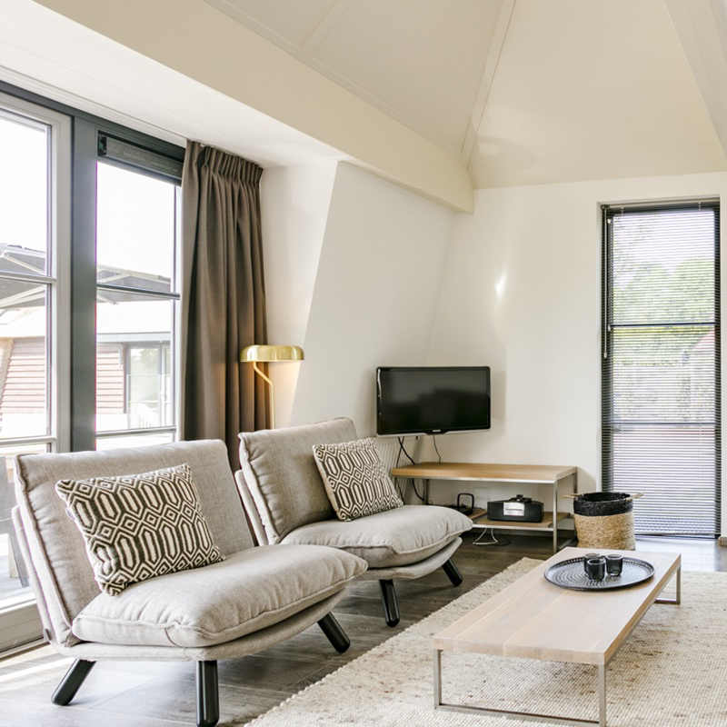 Woonkamer met fauteuils in het vakantiehuis bij zee