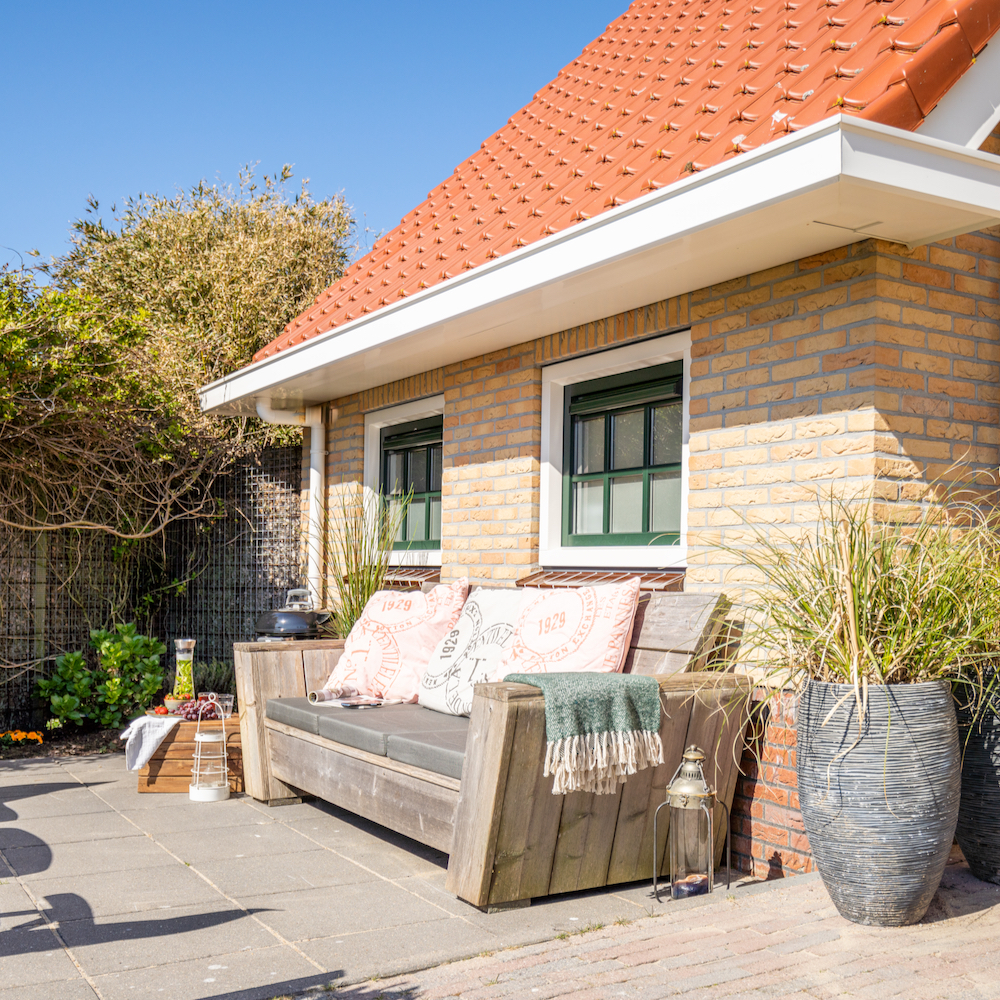 Terras met loungebank en BBQ bij het vakantie appartement op Ameland