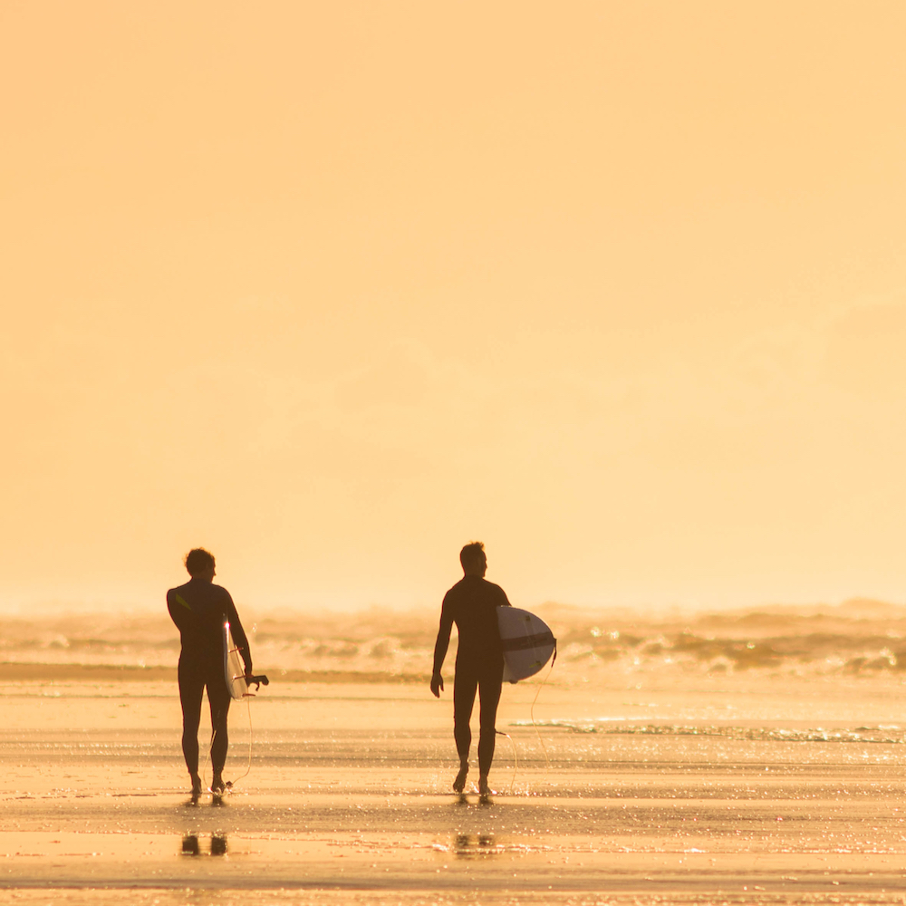 Twee surfers op Ameland in het avondlicht
